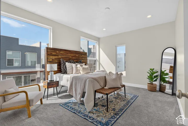 Spacious room featuring broad windows, recessed lighting, and a textured wood-finish headboard