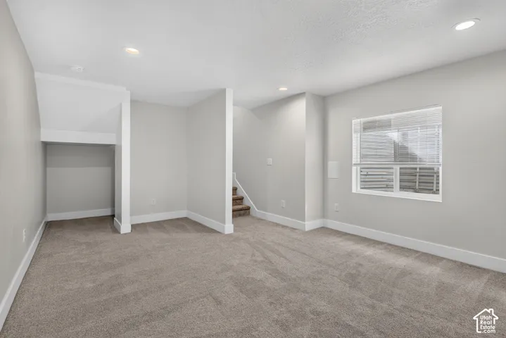 Carpeted flooring with recessed lighting, a window with blinds, and painted walls