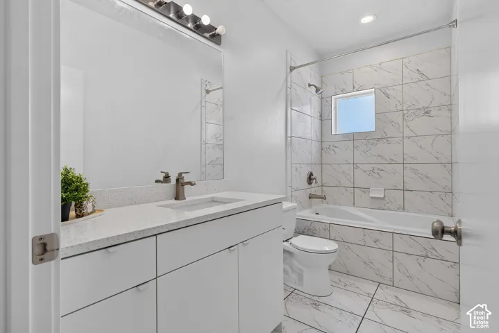 Vanity with a light-colored countertop, undermount sink, and brushed nickel faucet