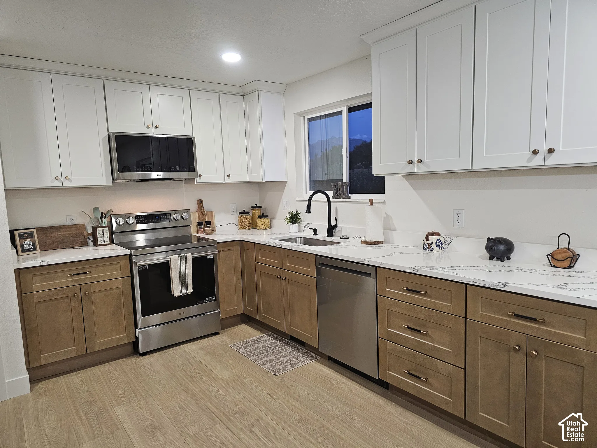 Custom kitchen with 2-tone cabinets, quartz counters, and stainless steel appliances