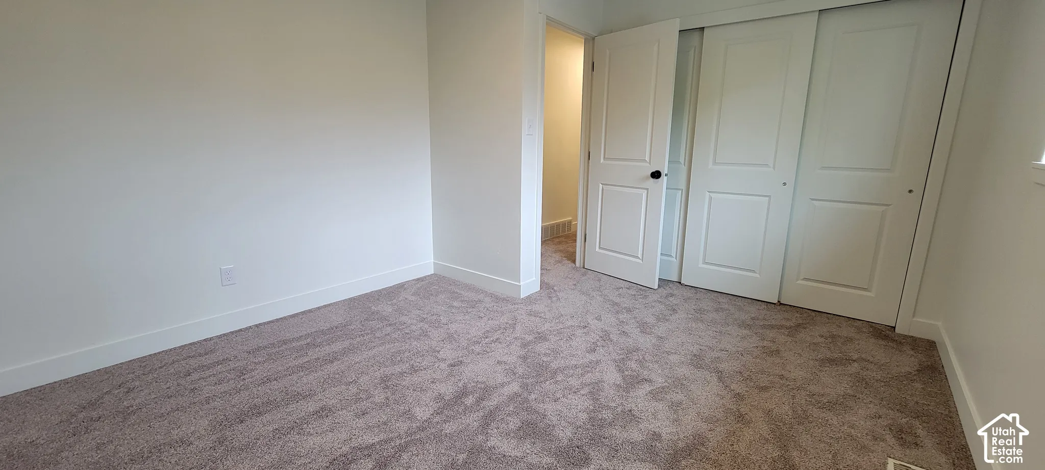 Neutral-toned carpeting, white walls, and white trim