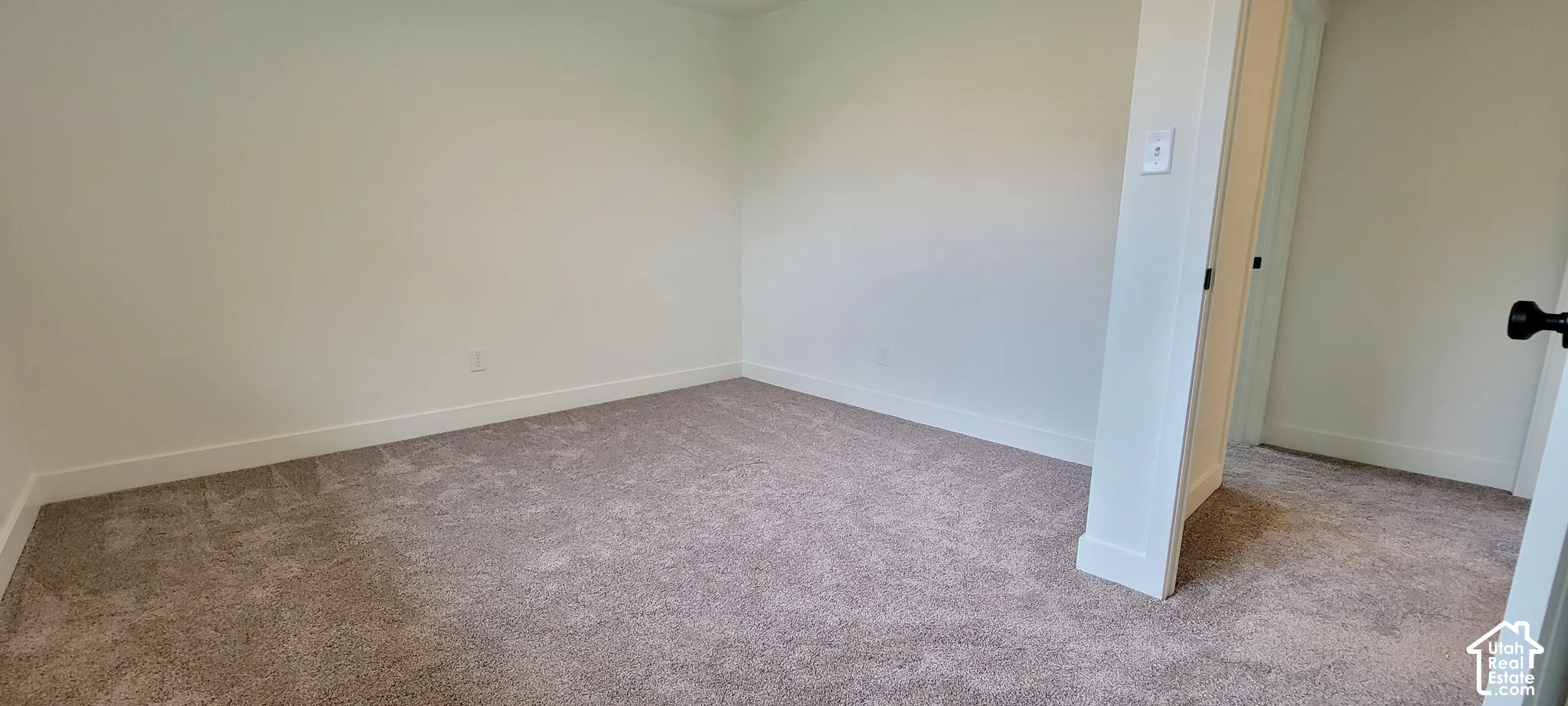 Neutral-toned carpeting, white painted walls, and white trim accents