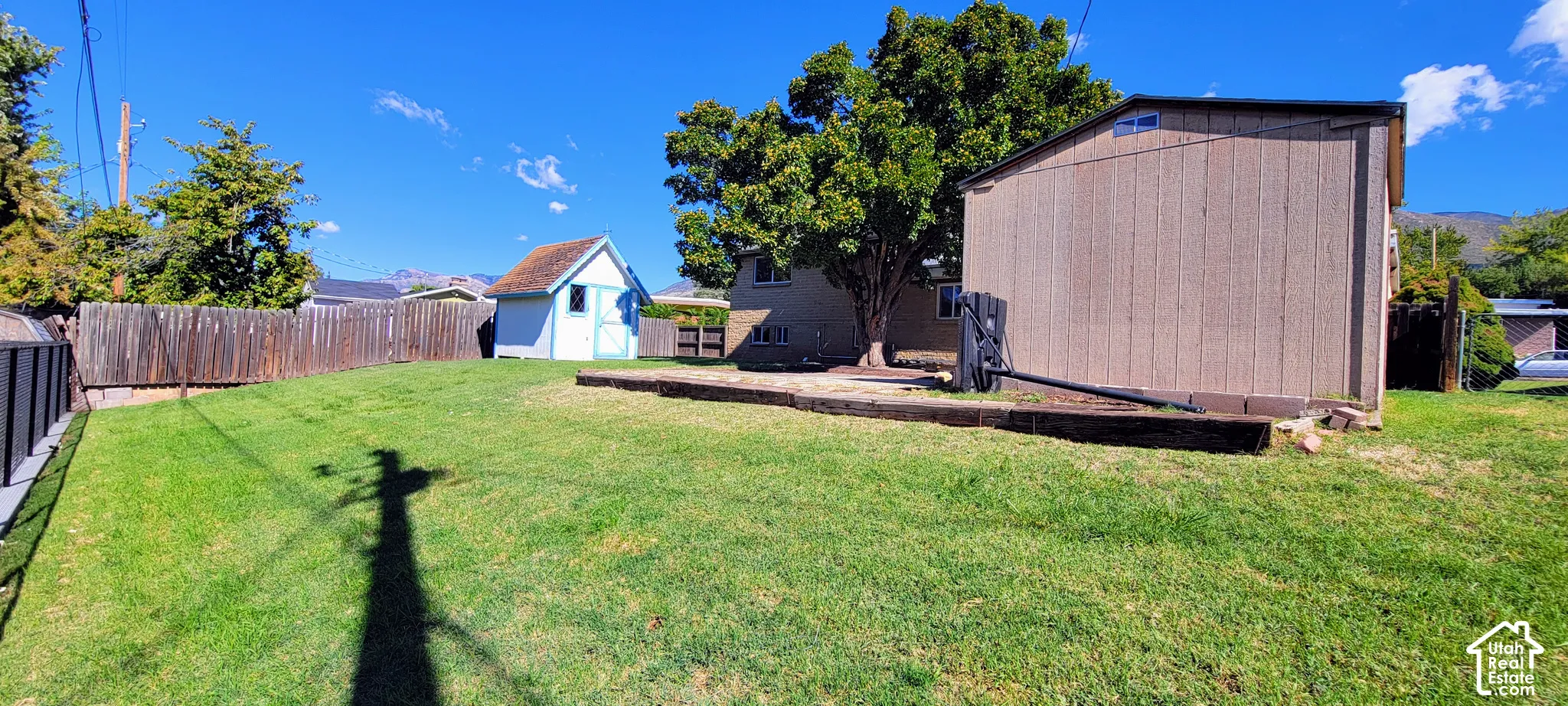 Expansive grassy lawn with a wood fence perimeter