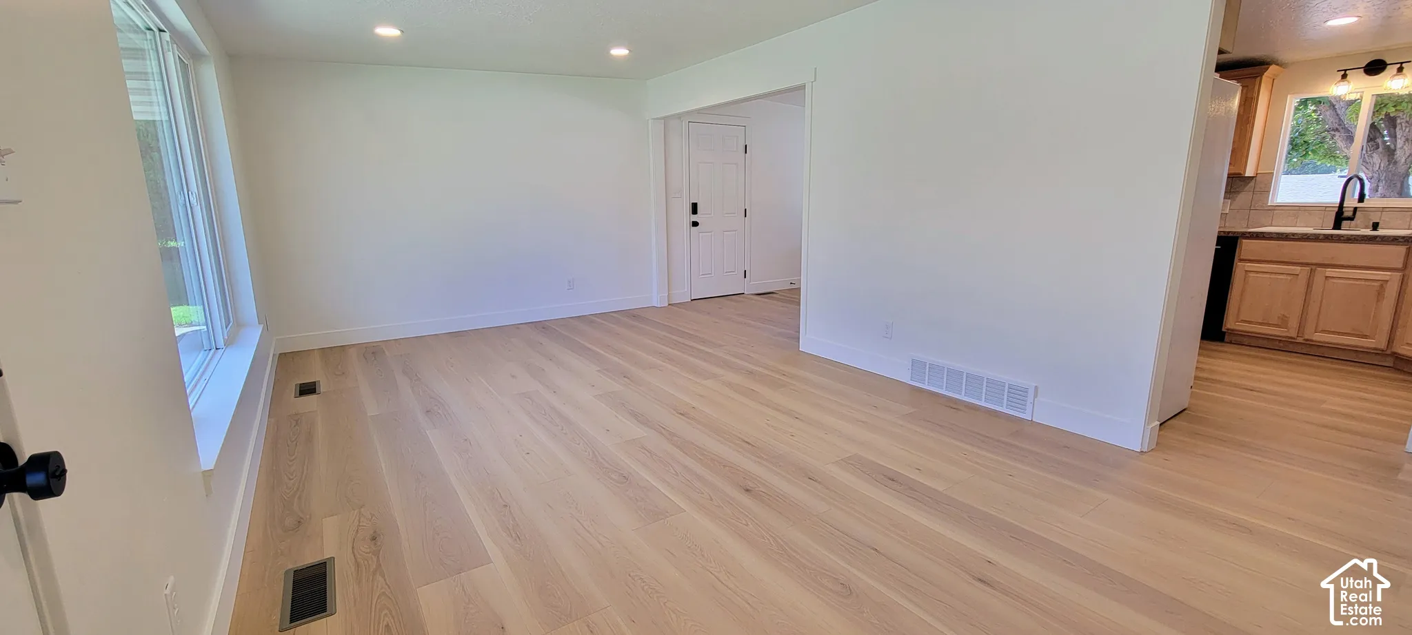 Recessed lighting illuminates wood-finish flooring