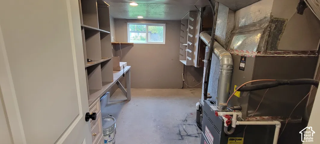 Room with built-in shelving, a work surface, and an HVAC system
