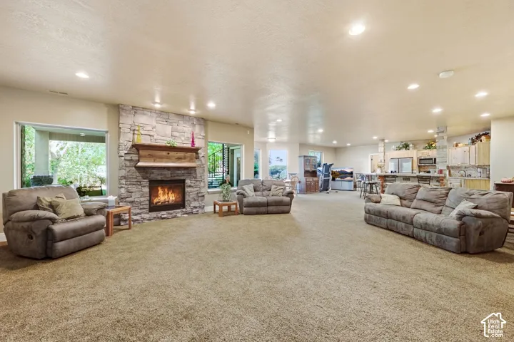 Spacious room with a stone-clad fireplace and a wood mantel
