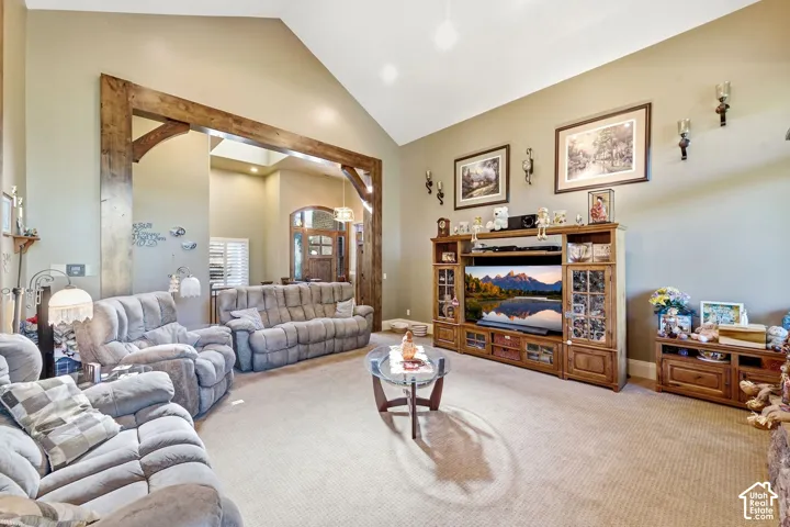 Vaulted ceiling with recessed lighting, exposed wood beams, and carpet flooring