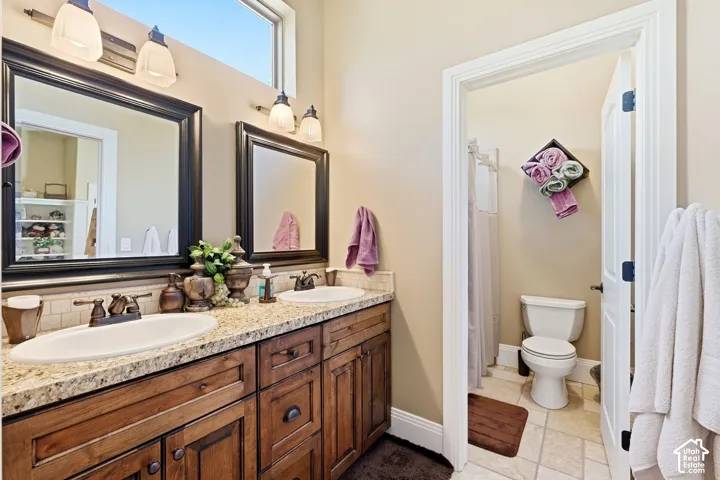 Dual vanity with granite-style countertop, undermount sinks, and wood-finish cabinetry