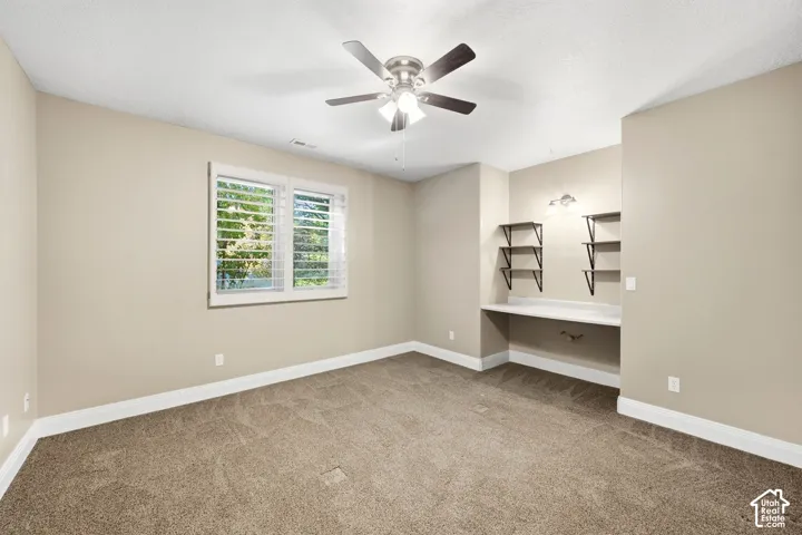 Recessed built-in desk with integrated shelving and wall-mounted lighting