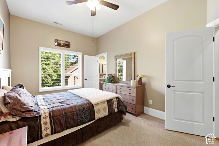 Vaulted ceiling with ceiling fan, white window shutters, and arched interior door