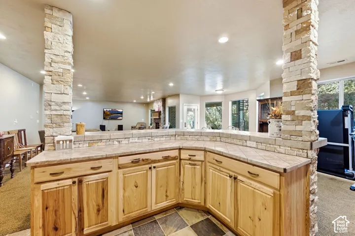Stone-clad columns and a curved bar with wood cabinetry