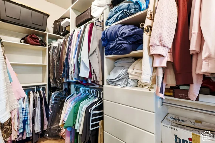 Custom-built closet system featuring integrated shelving, multiple hanging rods, and built-in drawers