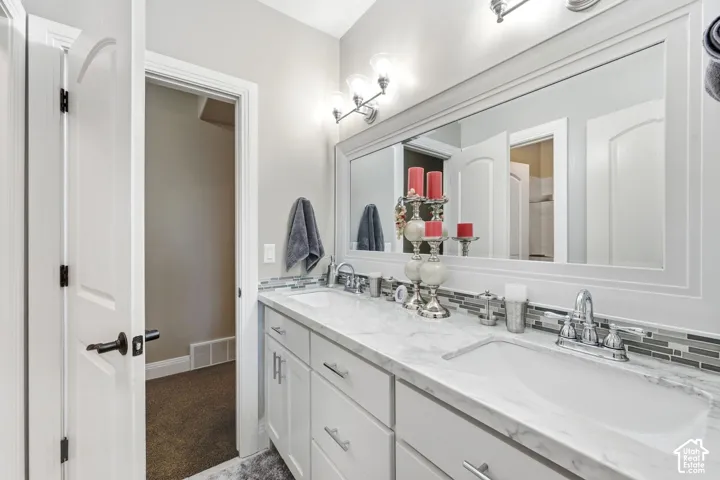 Dual vanity with under-mount sinks, a large framed mirror, and chrome fixtures