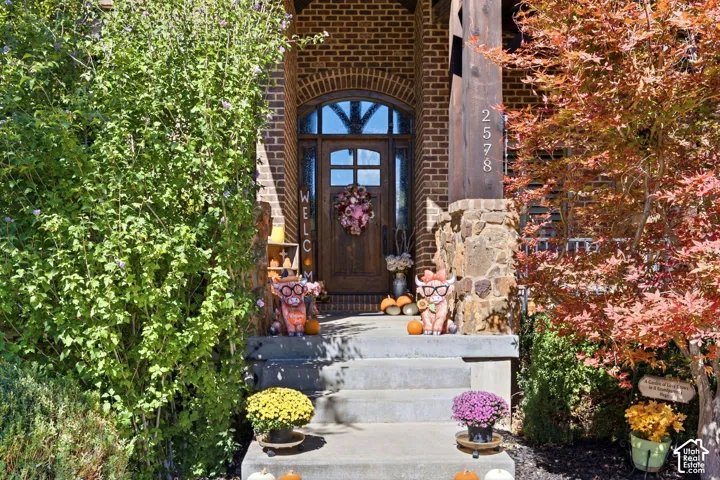 Brick facade with an arched entry and wood door featuring glass inserts
