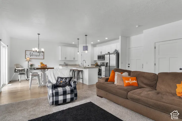Open-concept living space featuring wood-finish flooring, recessed lighting, and kitchen island with counter seating