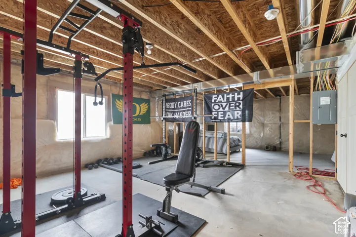 Unfinished basement with exposed ceiling joists and concrete flooring
