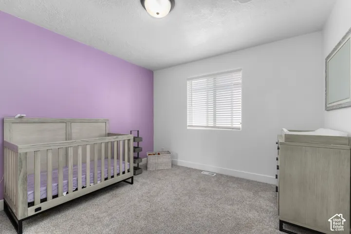 Recessed window with horizontal blinds, overhead flush mount lighting, and gray carpet flooring