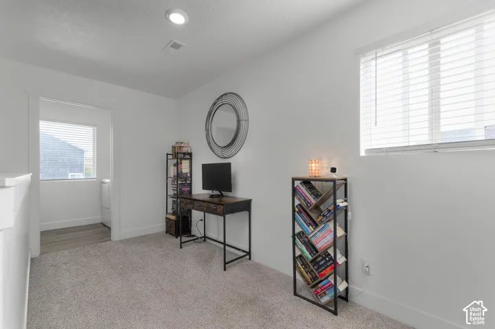 White walls, recessed lighting, and a window with blinds