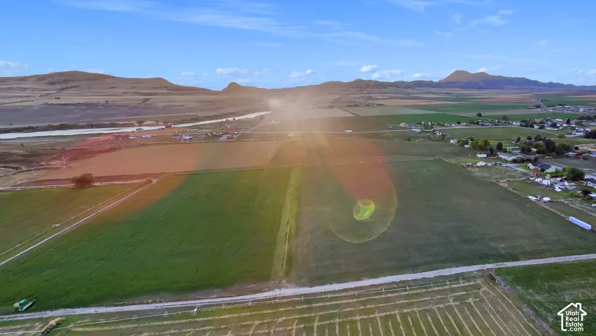 Expansive agricultural fields with distant mountains and a river