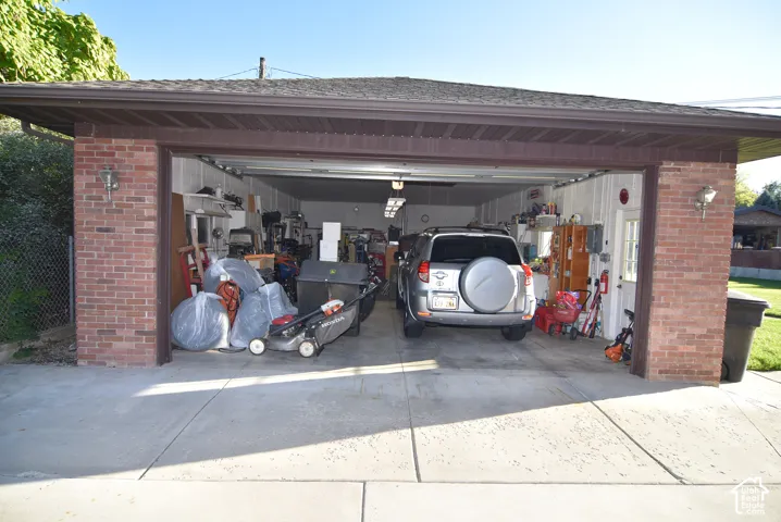 Detached 4--car garage with brick exterior, concrete driveway, and overhead lighting fixtures