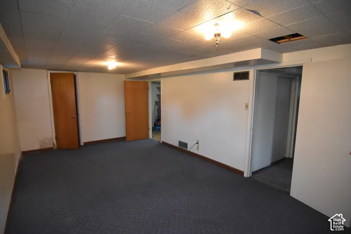 Carpeted flooring, acoustic tile ceiling, recessed lighting, baseboard trim, and multiple doorways
