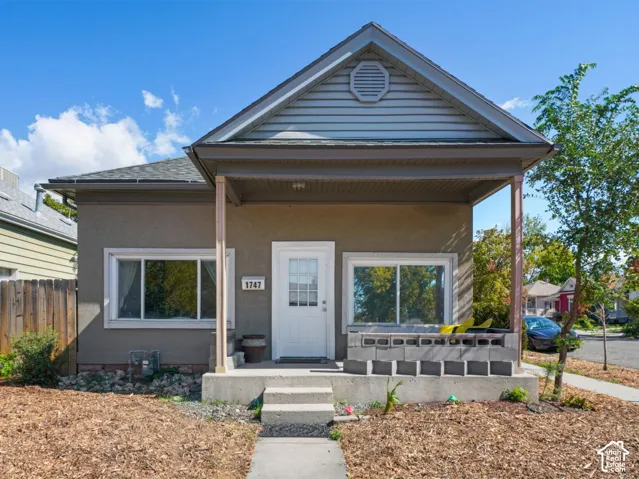 Stucco exterior with a gabled roofline and an inviting covered porch