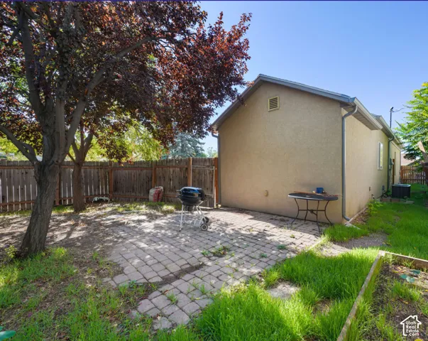 Private backyard with a paver patio and mature tree providing natural shade