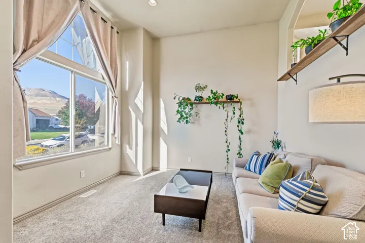 High vaulted ceilings, expansive window with mountain scenery, neutral wall tones, recessed lighting, and wall-mounted shelving