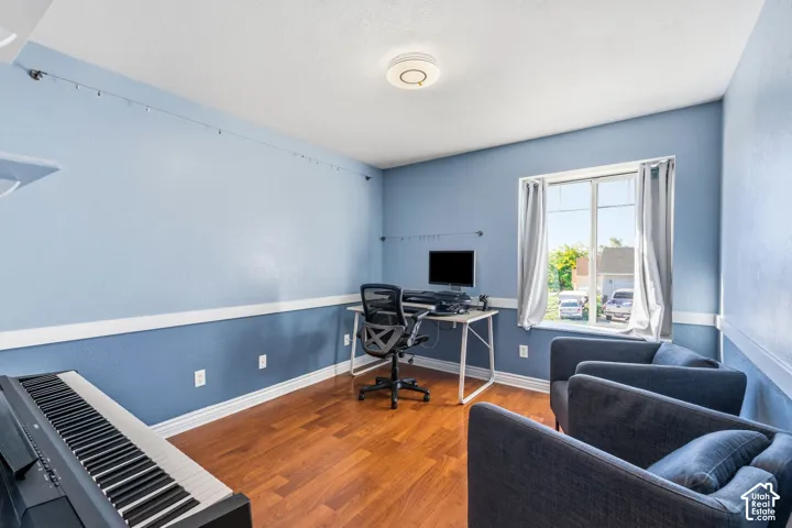 Wood-finish flooring, white trim, and a window with natural light