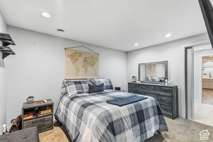Recessed lighting illuminates the space, featuring light gray walls and carpeted flooring