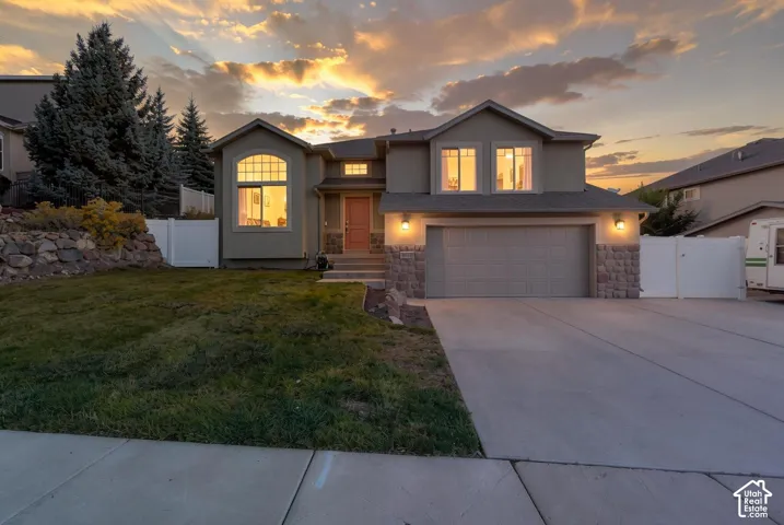 Two-story residence with a concrete driveway, two-car garage, and a peaked roofline