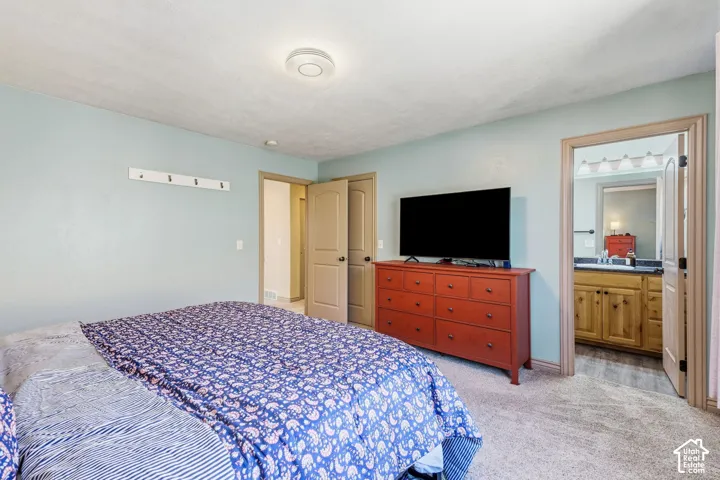 Carpeted flooring throughout, light blue wall paint, and a built-in wall rack