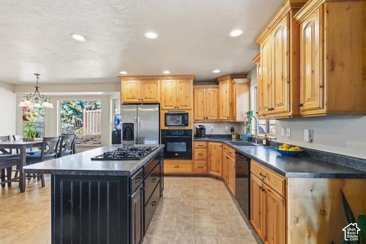 Kitchen featuring wood cabinetry, stainless steel appliances, a center island with a built-in cooktop, and recessed lighting
