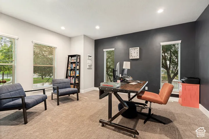 Neutral tone wall paint, accent wall, recessed lighting, multiple windows, carpet flooring