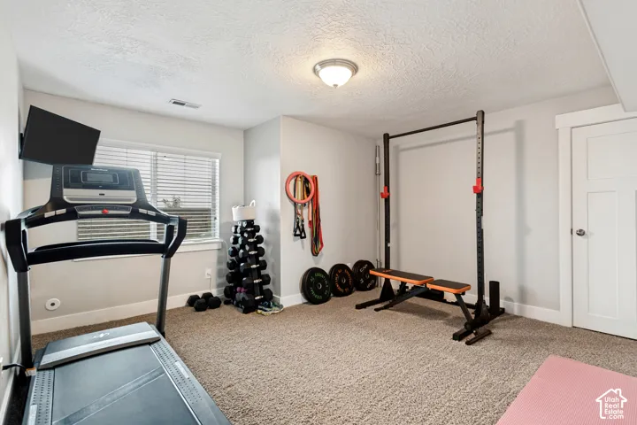 Carpeted floor with light-colored walls and a single window with blinds