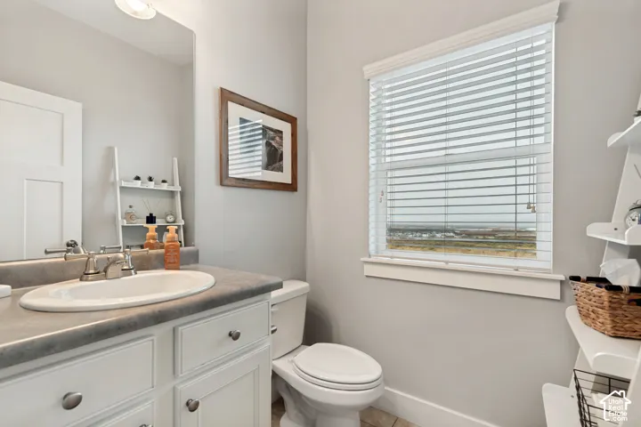 White vanity with brushed nickel hardware, integrated sink, and a framed mirror