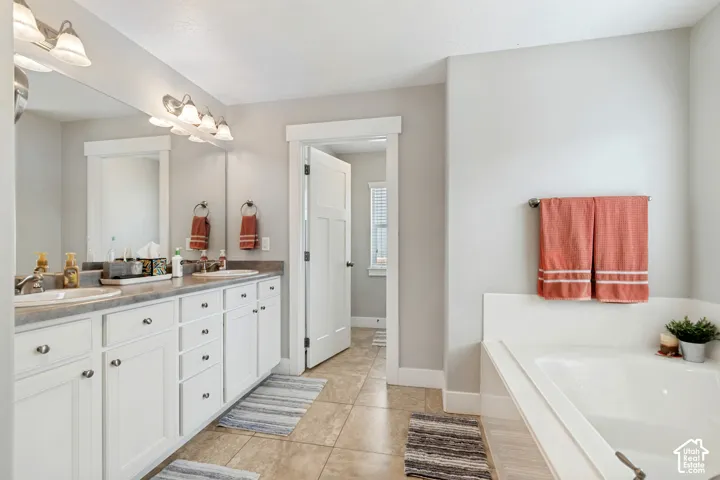 Dual vanity with white cabinetry, integrated sinks, and a large mirror