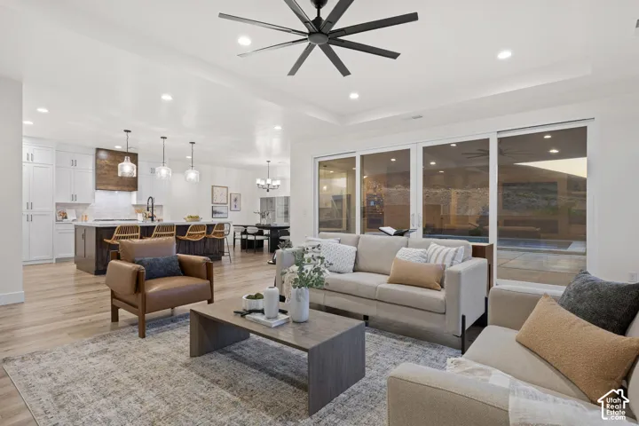 Open-concept living space featuring wood-finish flooring, a contemporary ceiling fan, and recessed lighting