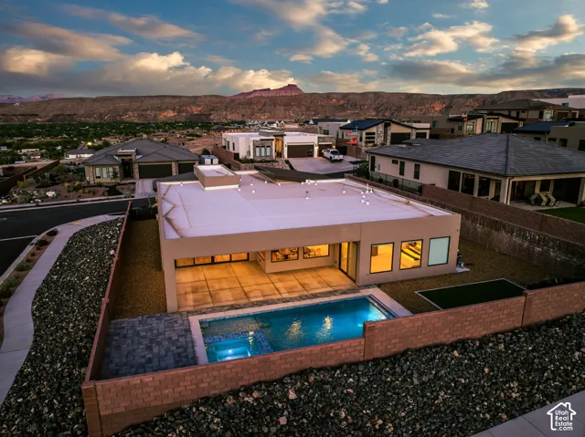 Contemporary exterior with a flat roofline, integrated swimming pool, and stone paver patio