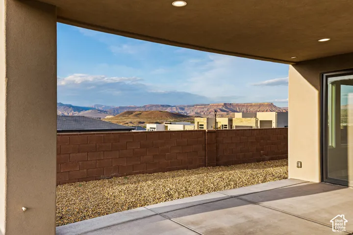 Covered patio with recessed lighting, concrete flooring, and a stone block privacy wall