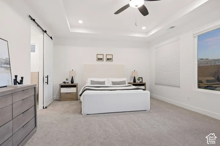 Tray ceiling with recessed lighting, ceiling fan, and carpeted flooring