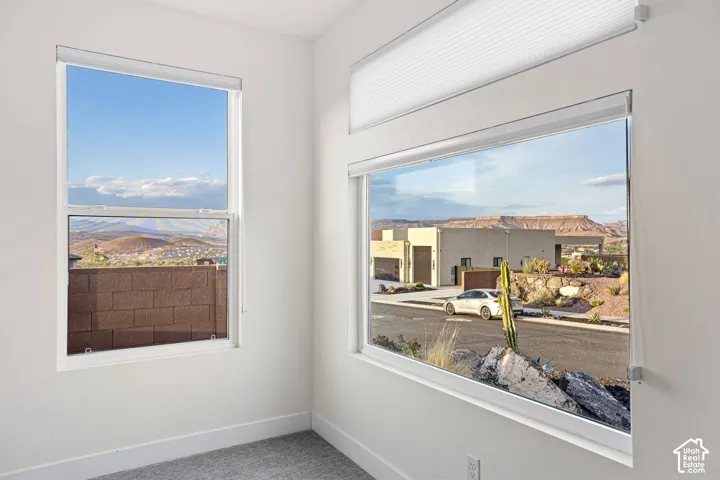 White walls, carpeted flooring, large window, horizontal window, window shades