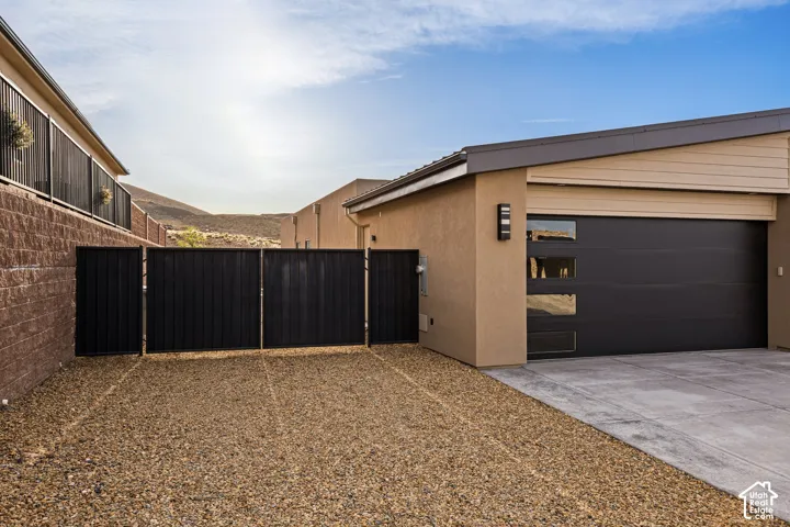 Modern garage with horizontal windows, gravel driveway, and exterior lighting fixture