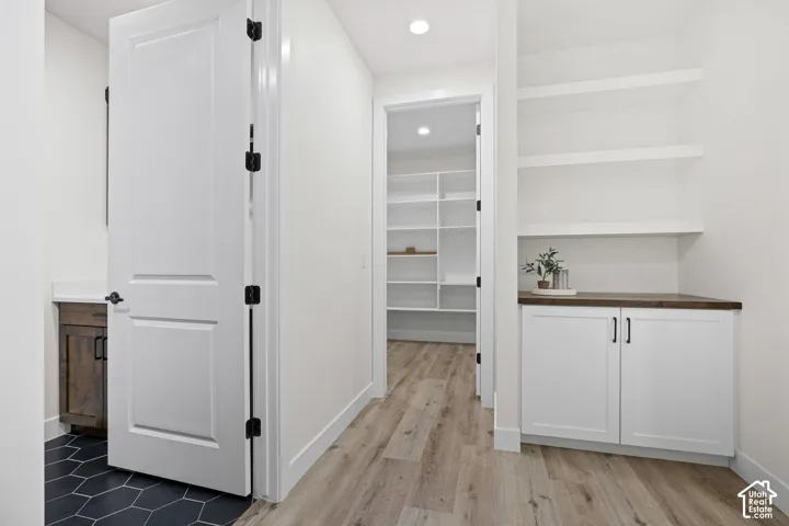 White built-in cabinetry with a wood-finish countertop and open shelving
