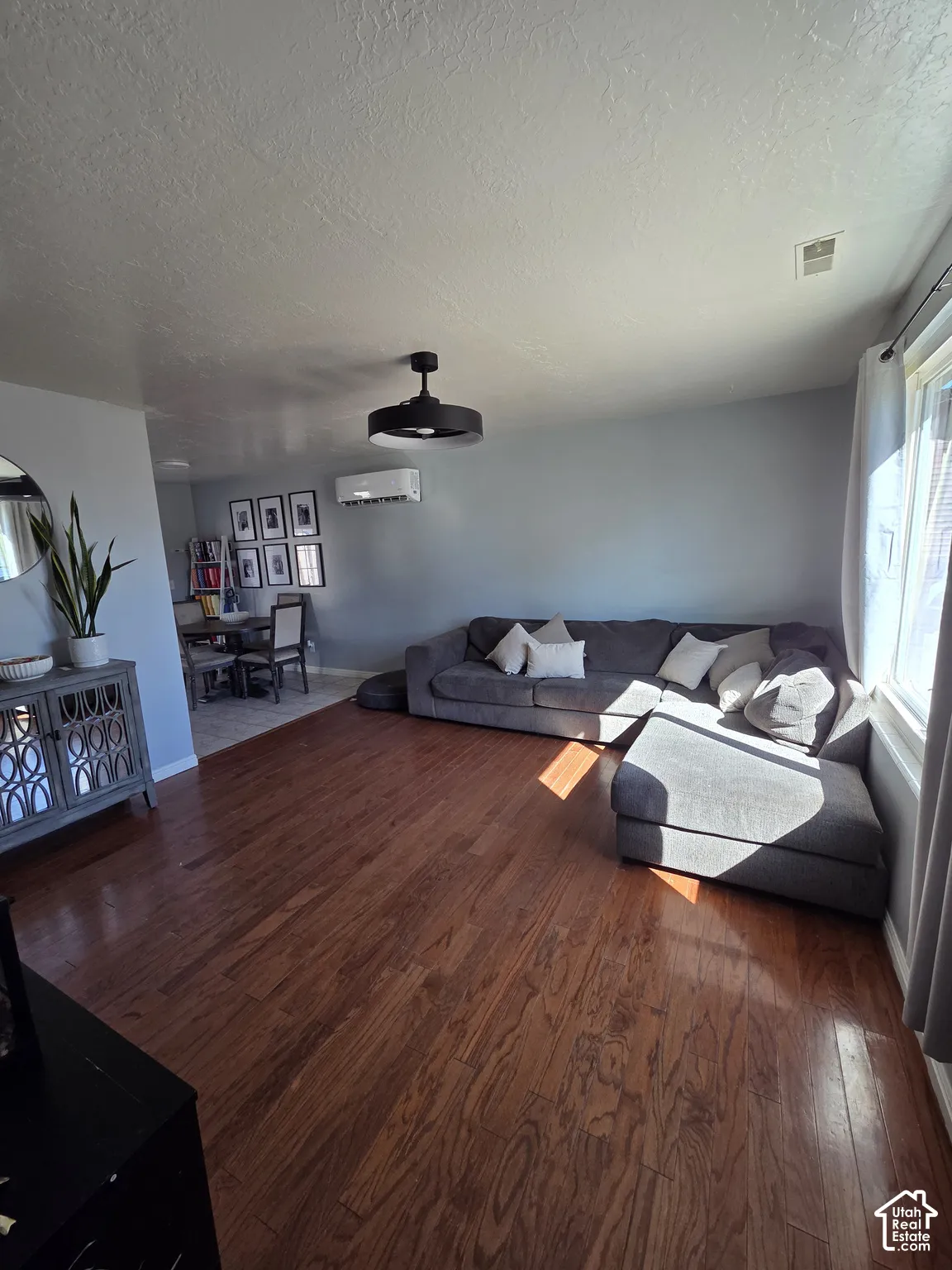Wood-finish flooring, contemporary ceiling fan, and wall-mounted air conditioning unit
