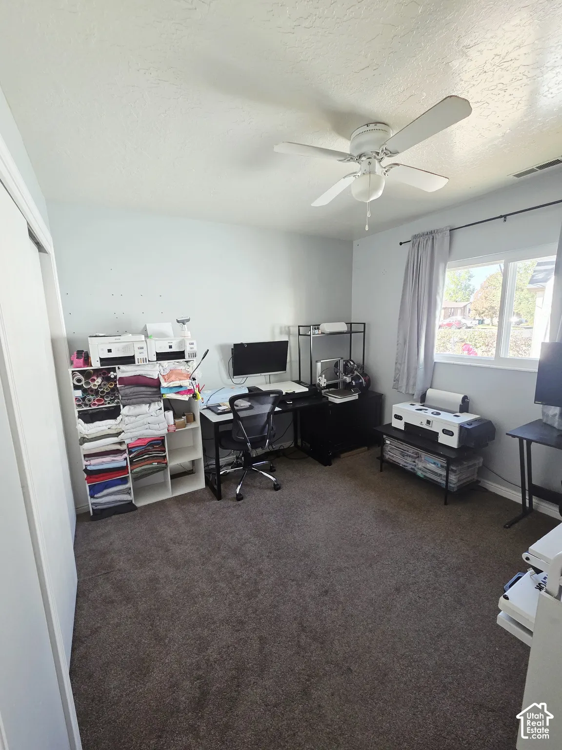 Wall-to-wall carpeting with a ceiling fan overhead