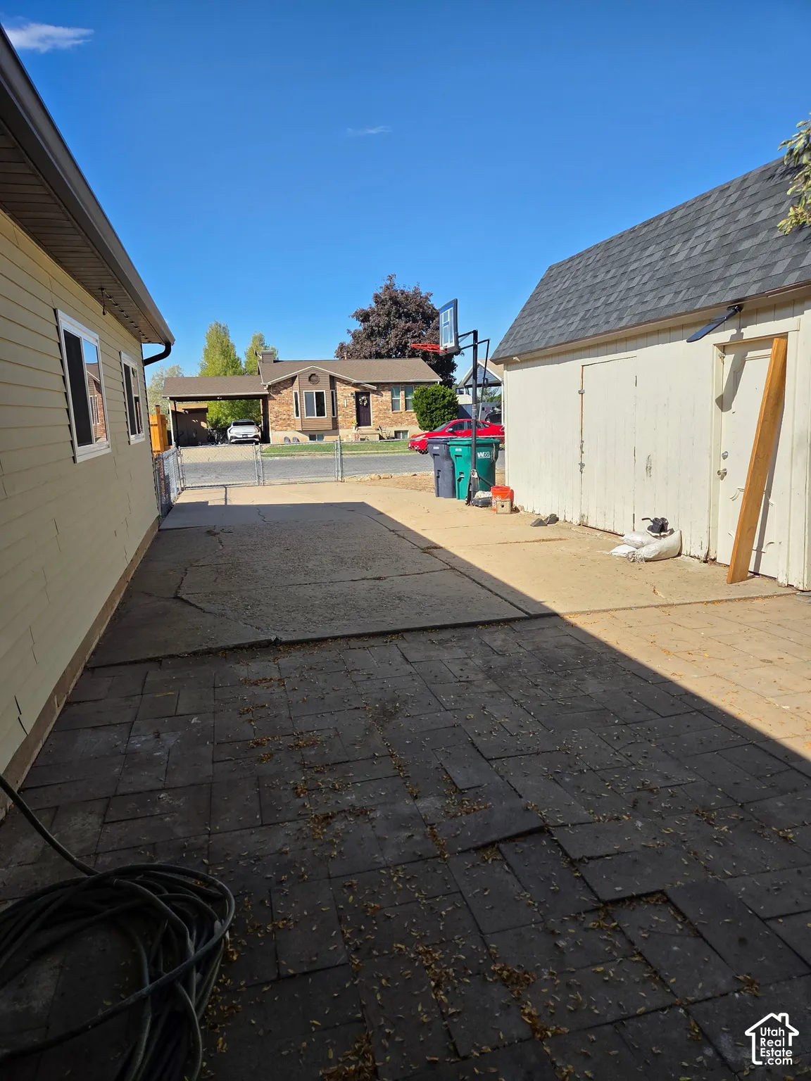 Paved walkway leading to a detached structure with an asphalt shingle roof