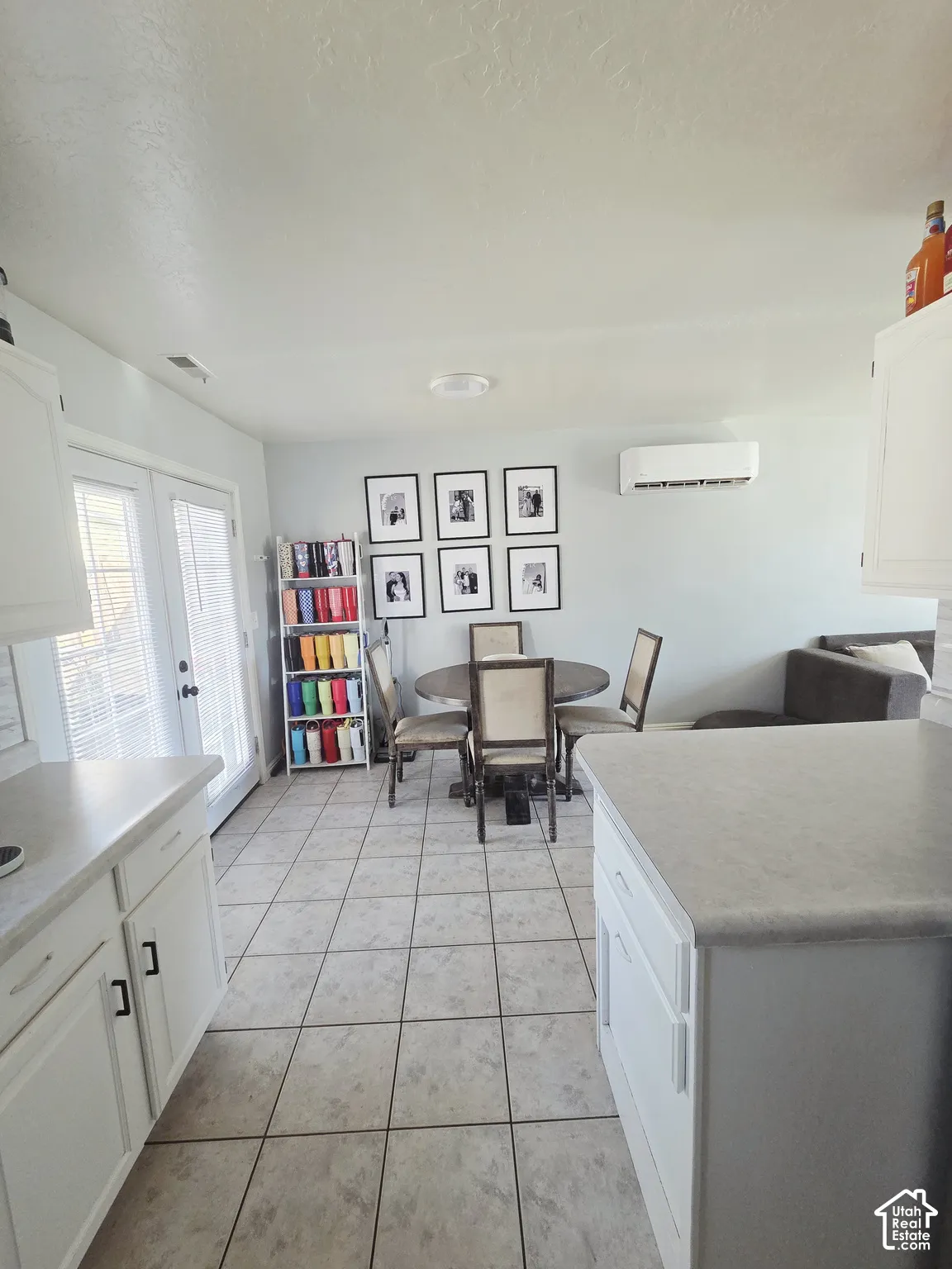 White cabinetry with dark hardware, light countertops, and tile flooring