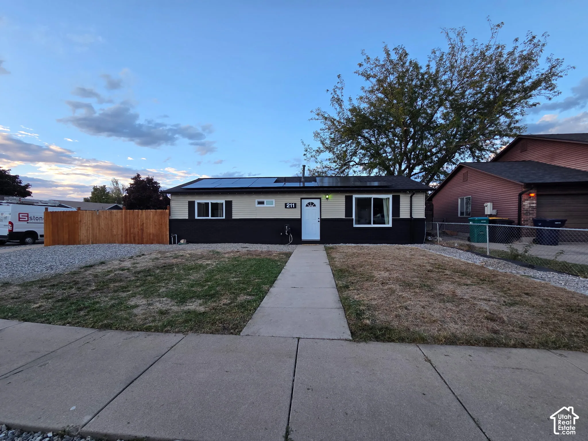 Contemporary single-story residence featuring a clean facade with black and white exterior trim, central entry door, and dual front-facing windows