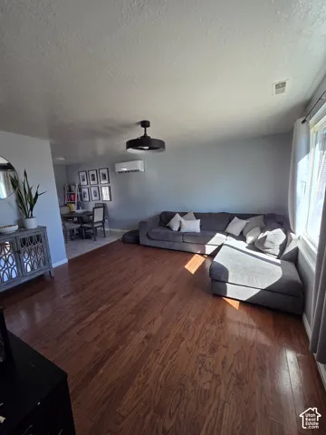 Wood-finish flooring, contemporary ceiling fan, and wall-mounted air conditioning unit